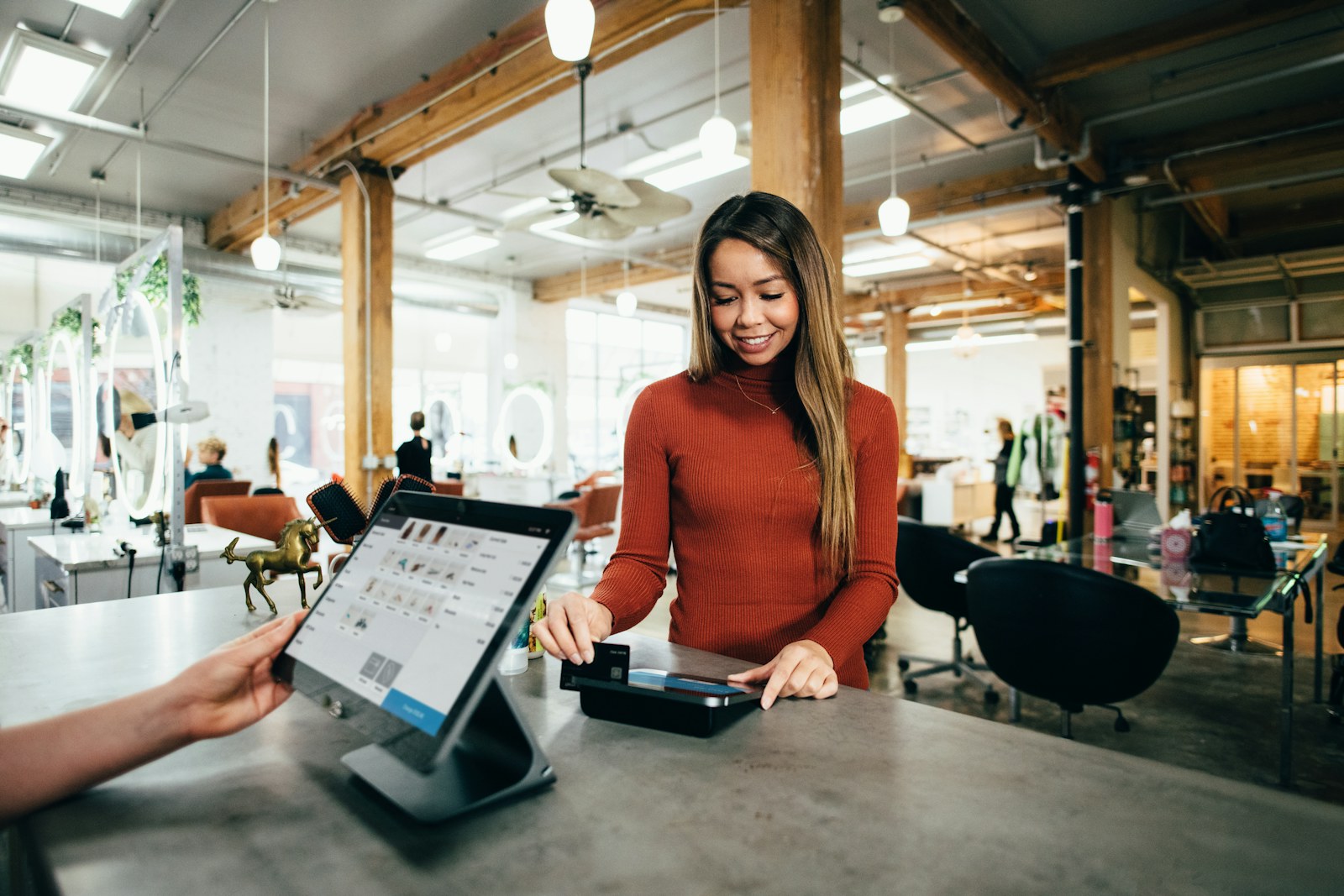 Merchant using a point of sale to help a customer at checkout